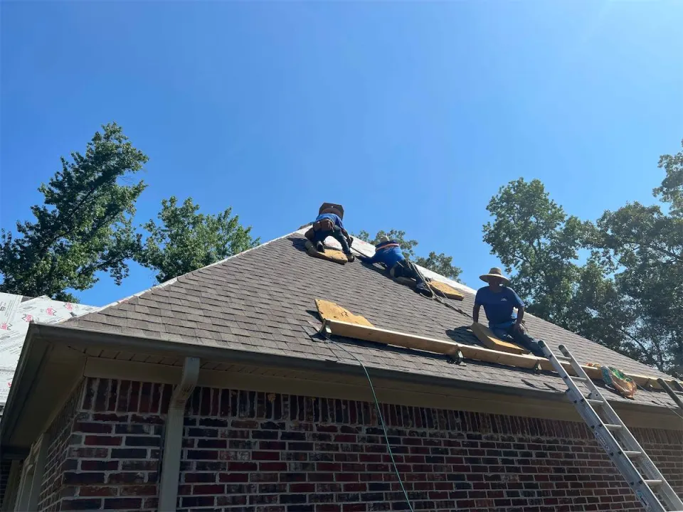 Crew re-roofing a brick home