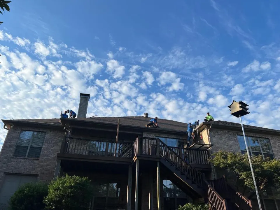 Crew on the roof of a two-story home
